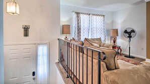 A bedroom with a bed, a nightstand, a lamp, a fan, and a window with curtains. - Maryland Vacation Home Near US Capital! (Riverdale Park)