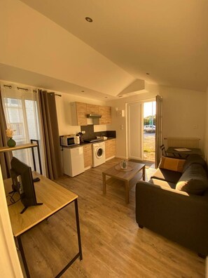 A compact living space with a kitchenette, a dining area, and a sofa.
