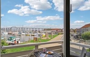 A balcony with a view of a marina, a bridge, and a row of houses. - Stunning apartment in Rudkøbing (Rudkøbing)