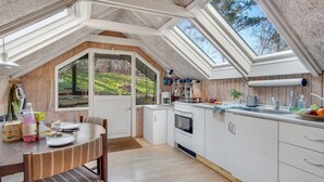 A cozy kitchen with a wooden interior, white cabinets, and a skylight. - 2 bedroom awesome home in Sejerø (Sejerø)
