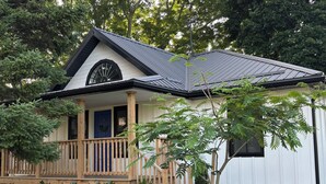 A house with a porch, a small garden, and a metal roof. - Gorgeous Gem in Niagara’s Wine Country (Niagara Falls)