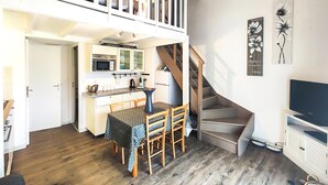 A compact living space with a kitchen, dining area, and a staircase leading to an upper level. - Amazing home in Agde with outdoor swimming pool (Agde)