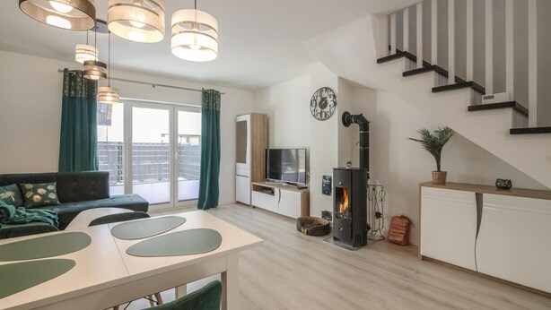 A modern living room with a sofa, TV, fireplace, and staircase. - Pet friendly home in Klodawa with sauna (Klodawa)