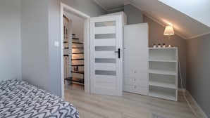 A bedroom with a bed, a wardrobe, a desk, and a shelving unit. - Pet friendly home in Klodawa with sauna (Klodawa)