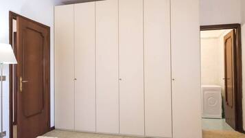 A room with a large wardrobe, a door, and a washing machine.
