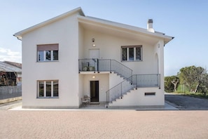 Un bâtiment à deux étages doté d’un balcon, d’un escalier et d’une porte.