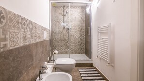 A bathroom with a shower, toilet, sink, and a towel rack. - "The LOFT - ITALY COURSE" (Pisa)