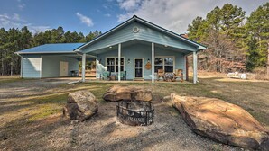 A rustic building with a porch, large rocks, and a fire pit. - Hogden Home Near the Black Fork River & Trails! (Hodgen)