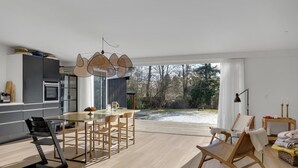A modern kitchen with a dining area, large windows, and a view of a snowy landscape. - Stunning home in Gilleleje with kitchen (Gilleleje)