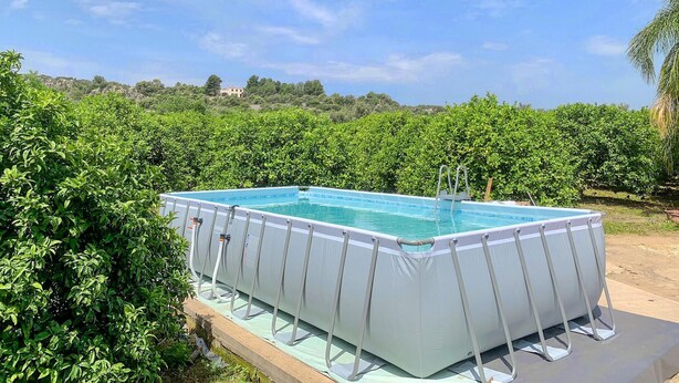 Una piscina exterior envoltada de vegetació exuberant.
