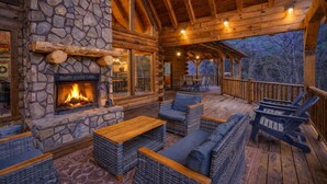 A log cabin with a stone fireplace, outdoor seating area, and a covered deck. - Blue Ridge Lodge Hocking Hills: Accessible Luxury (Logan)
