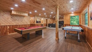 A wooden-paneled room with two pool tables, a sofa, and a television. - Blue Ridge Lodge Hocking Hills: Accessible Luxury (Logan)