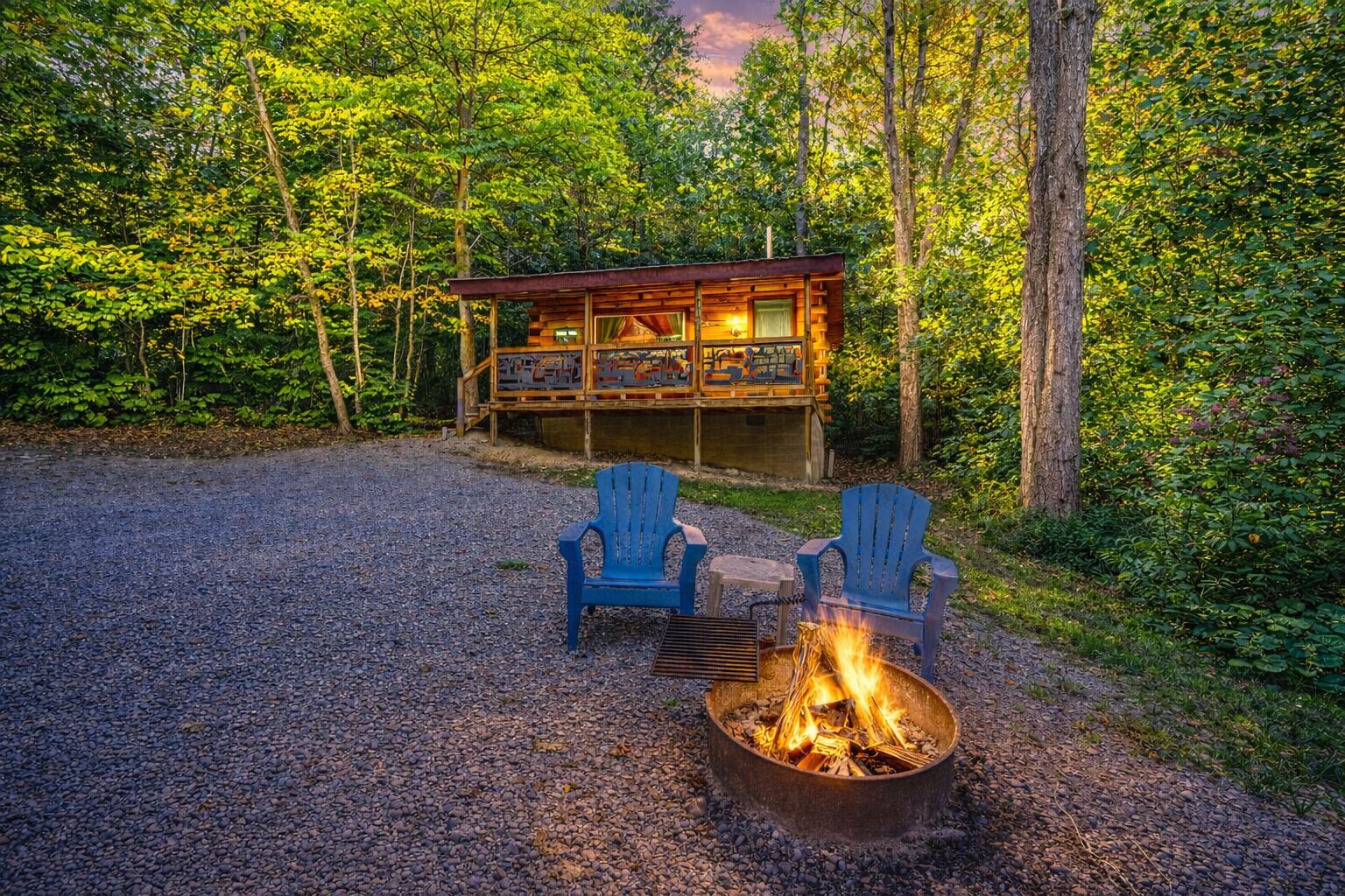 Eine Hütte mit Feuerstelle und zwei Stühlen in einer Waldlandschaft.