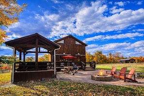 A rustic wooden building with outdoor seating and a fire pit.
