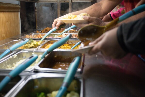 Una mesa de buffet con varios utensilios de servir y una variedad de alimentos.