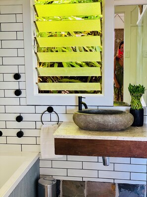 A bathroom with a white brick wall, a stone sink, a mirror, and a potted plant. - Surf Break On Bruxner - Korora (Pet Friendly) (Korora)