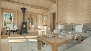 Un ambiente accogliente in legno con camino, divano e tavolino.