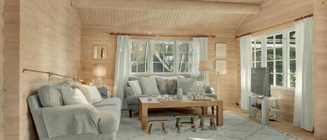 A cozy room with a sofa, a table, and a TV.