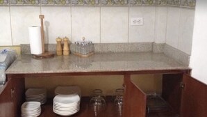 Een keuken met een aanrecht, een spoelbak en een betegelde spatwand.