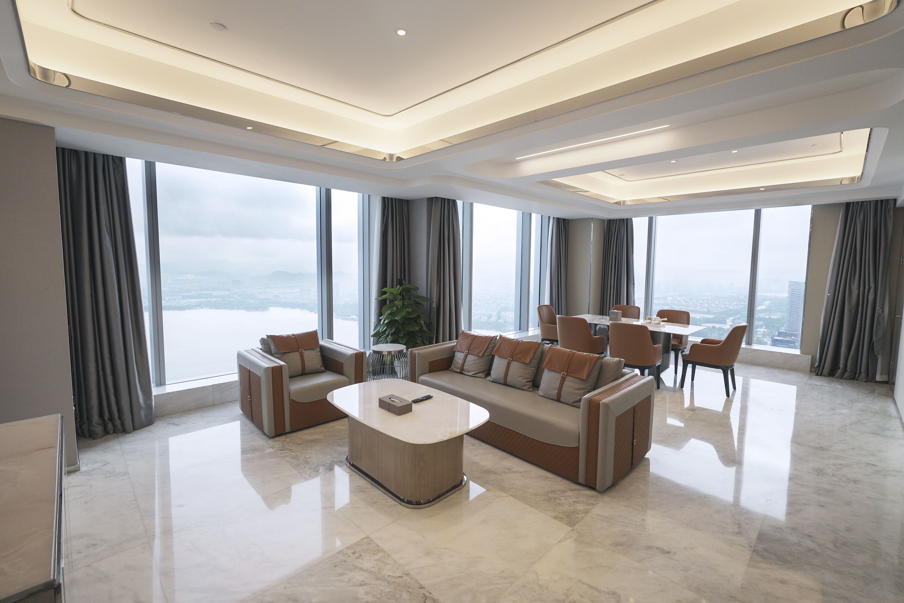 Una sala de estar amplia con un sofá seccional grande, una mesa de centro y un comedor con sillas y una mesa.