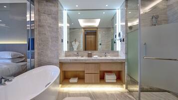 Un baño moderno con una bañera independiente, un espejo grande y una zona de ducha con mampara de vidrio.