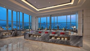 A modern kitchen with a marble countertop, large windows, and a city view. - Wyndham Shaoxing Keqiao (Shaoxing)