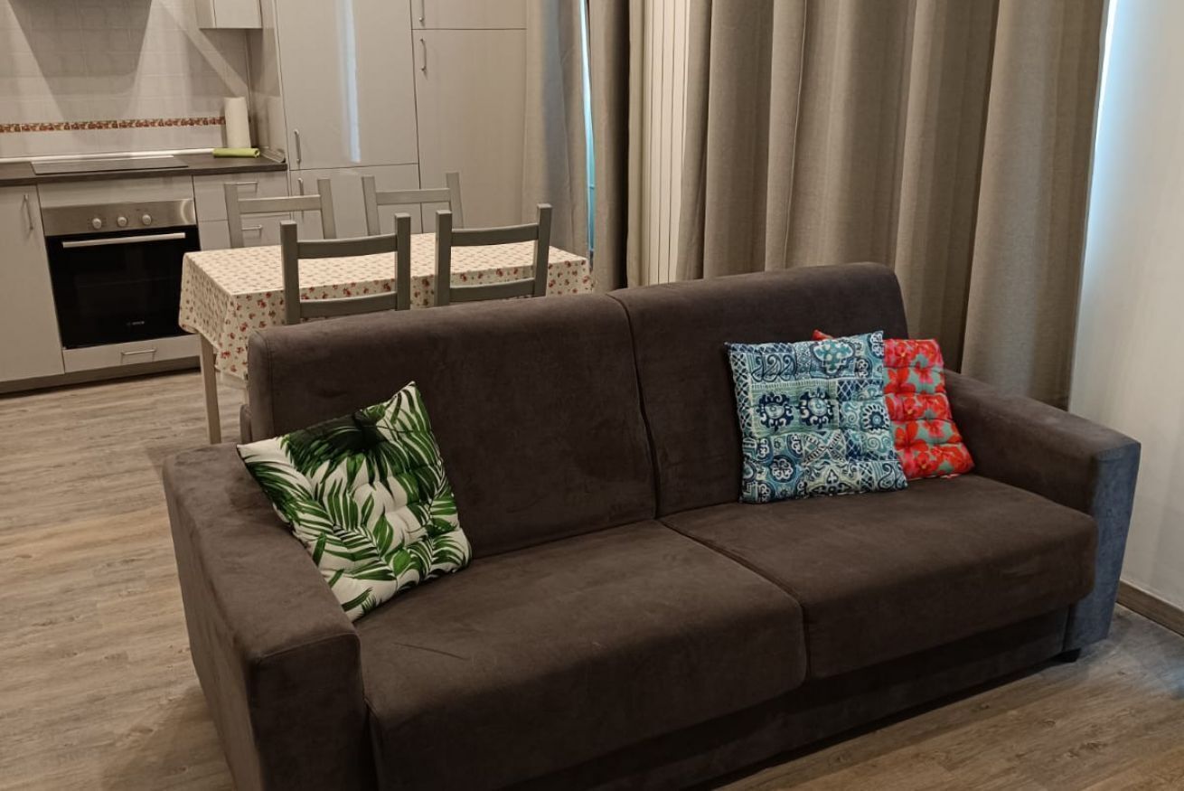 Ein braunes Sofa mit gemusterten Kissen in einer modernen Küchenzeile.