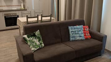 Ein braunes Sofa mit gemusterten Kissen in einer modernen Küchenzeile.
