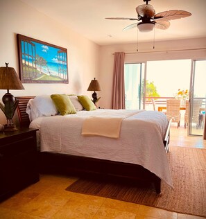A bedroom with a bed, two lamps, a ceiling fan, a painting, and a view of the outdoors. - (20% OFF) Artsy & Chic Oceanfront hideaway: exclusive Cap Cana Marina district (CAP CANA)