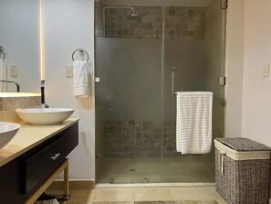 A bathroom with a large mirror, a white sink, a glass-enclosed shower, and a wicker laundry basket. - (20% OFF) Artsy & Chic Oceanfront hideaway: exclusive Cap Cana Marina district (CAP CANA)