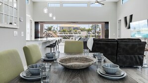 Un espace repas moderne avec une longue table, des chaises et un élément décoratif central en fibres tressées.