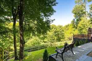 Un banc donnant sur un jardin, avec une clôture en bois et un bâtiment en arrière-plan.
