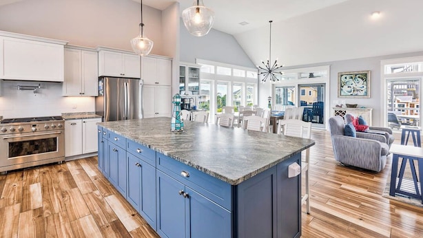 A spacious kitchen with blue cabinets, a large island, stainless steel appliances, and pendant lighting. - Beach Blessings | 950 ft to the beach | Private Pool, Hot Tub, Community Pool (Corolla)