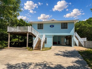 A two-story house with a covered porch, a staircase leading to the second floor, and a sign reading 'The Great Escape.' - The Great Escape - 4 BR beach home w/Private Pool only 2.5 blocks from the ocean! (Southern Shores)