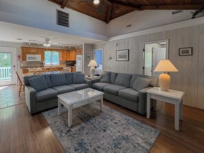A spacious living area with a sofa set, a coffee table, and a lamp.