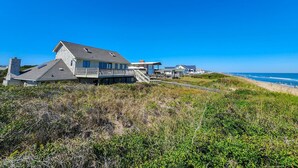 A beachfront property with a large house, a smaller building, and a pathway leading to the beach.