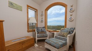 A cozy room with wicker furniture, a wooden bench, and a view of the outdoors. - Duckaway Home - Unwind in this 5 BR oceanside home in Duck w/Private Pool! (Duck)