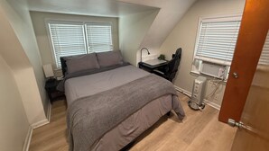 Une chambre à coucher avec un lit, un bureau et un radiateur.