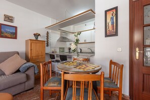Un salon chaleureux avec un canapé, un meuble en bois et une table à manger avec des chaises.