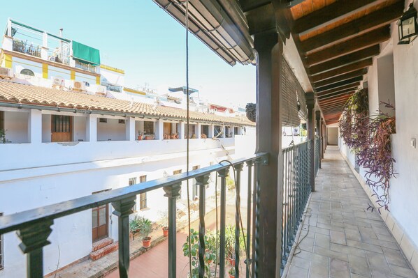 Uma varanda com vista para um pátio e edifícios.