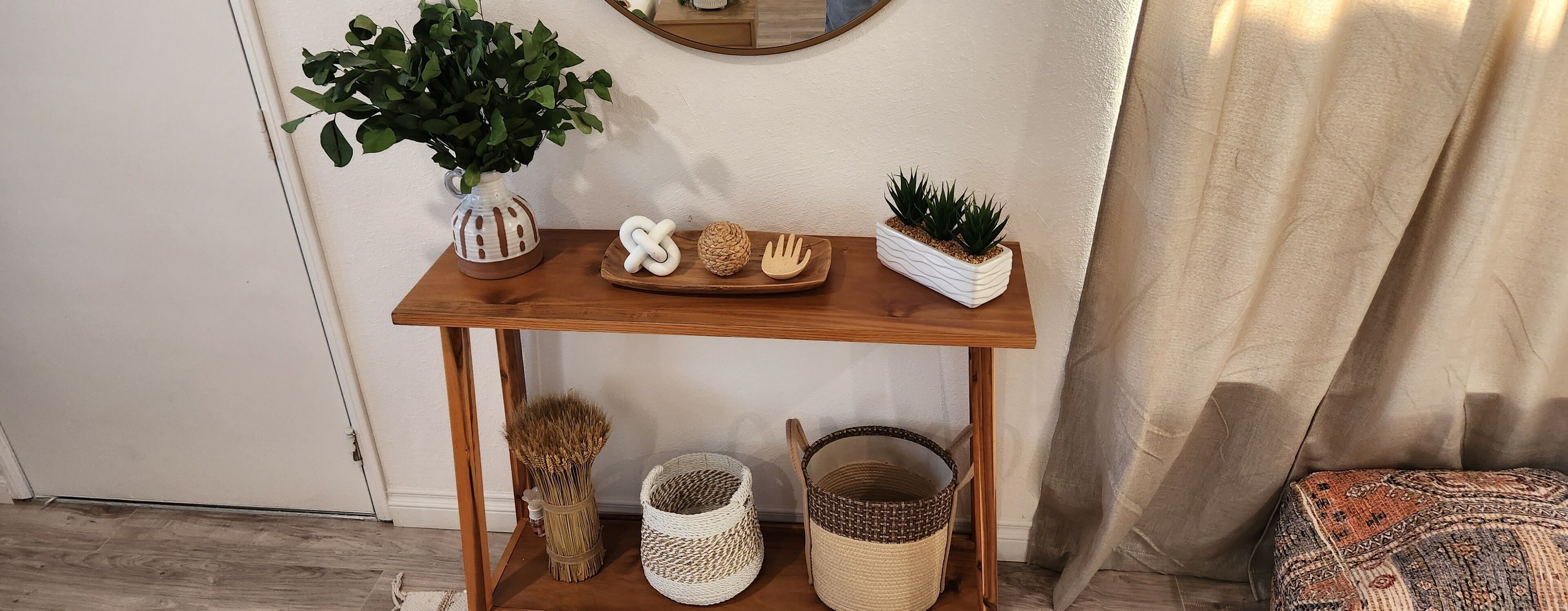 A wooden console table with decorative items, a potted plant, and woven baskets.