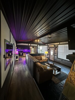 Ein modernes Wohnzimmer mit einer Couch, einem Couchtisch und einer Küchenzeile im Hintergrund.