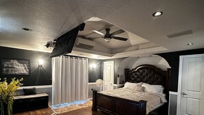 A bedroom with a large bed, a ceiling fan, and a view of the outdoors. - Cozy Cove with Beach, Dock, and Indoor Sauna (Sunrise Beach)