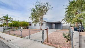 A residential property with a fenced yard, a small house, and a garage. - Cozy home! 18 min away from Strip and Fremont! (North Las Vegas)