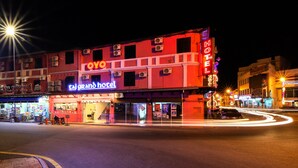 A hotel with a neon sign, multiple air conditioning units, and a well-lit entrance. - Taj Grand Hotel (Malacca City)