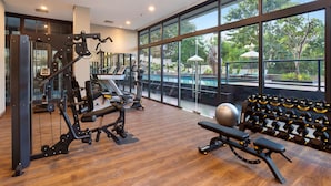 A gym with exercise equipment, a bench, and dumbbells. - Sima Sumba Hotel (Tambolaka)