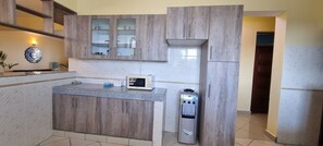 A kitchen with wooden cabinets, a microwave, and a water dispenser.