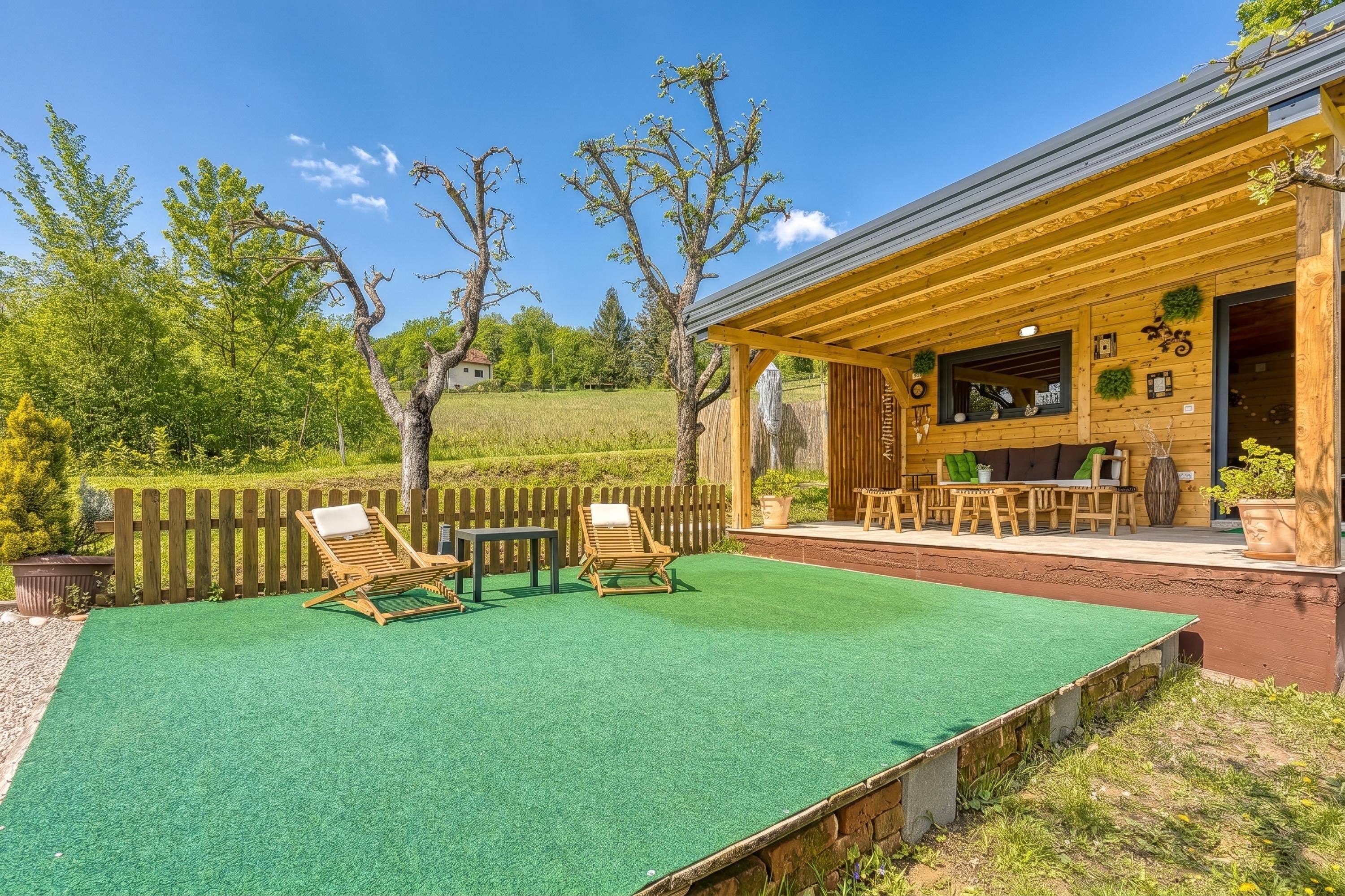 Una baita di legno con patio, posti a sedere all'aperto e vista sulla foresta circostante.