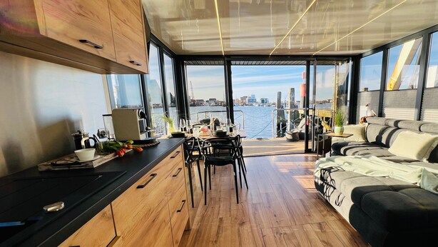 Ein modernes Interieur mit Holzboden, einem Essbereich und einer Couch.