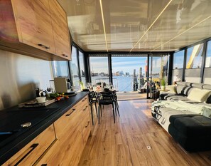 A modern interior with a wooden floor, a dining area, and a sofa.